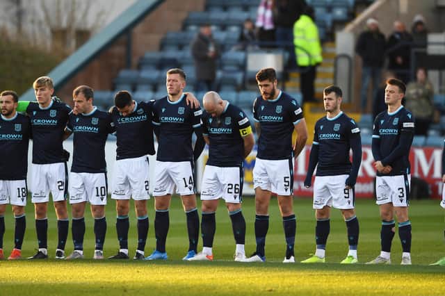 Dundee players observe a minute's silence to club legend Doug Cowie, who has died aged 95