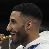 Britain's Galal Yafai bites his gold medal during the medal ceremony for the men's flyweight boxing competition at the 2020 Olympics. Picture: Themba Hadebe/AP