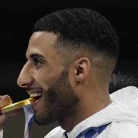 Britain's Galal Yafai bites his gold medal during the medal ceremony for the men's flyweight boxing competition at the 2020 Olympics. Picture: Themba Hadebe/AP
