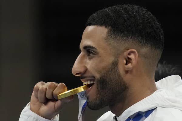 Britain's Galal Yafai bites his gold medal during the medal ceremony for the men's flyweight boxing competition at the 2020 Olympics. Picture: Themba Hadebe/AP