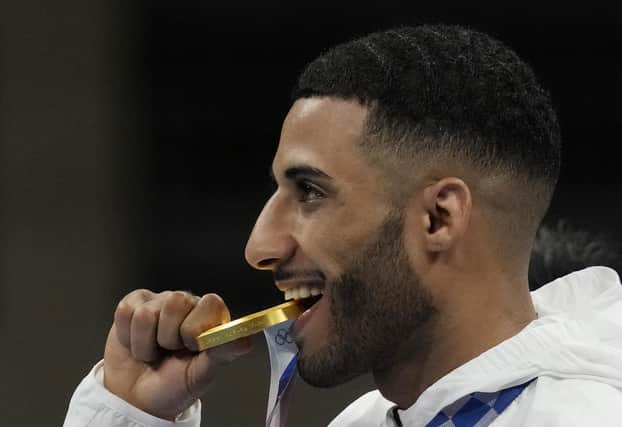 Britain's Galal Yafai bites his gold medal during the medal ceremony for the men's flyweight boxing competition at the 2020 Olympics. Picture: Themba Hadebe/AP