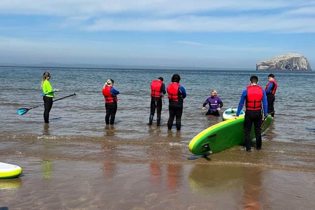 Edge Group Scotland's day programme participants during a supported Stand Up Paddleboarding session