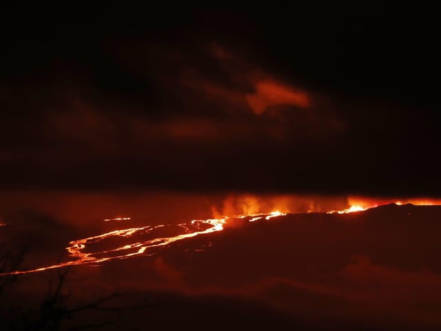 A river of lava flows down from Mauna Loa, Monday, Nov. 28, 2022, near Hilo, Hawaii. Mauna Loa, the world's largest active volcano erupted Monday