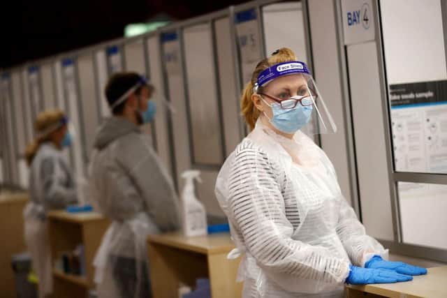 Health workers prepare to assist at a NHS Test and Trace Covid-19 testing unit at the Civic Centre in Uxbridge, Hillingdon, West London in 2021. Photo by ADRIAN DENNIS/AFP via Getty Images