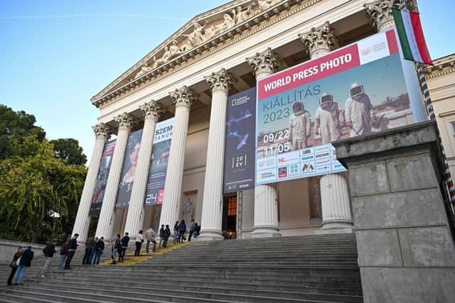 People wait in the queue to visit the exhibition of the World Press Photo at the Hungarian National Museum in Budapest.