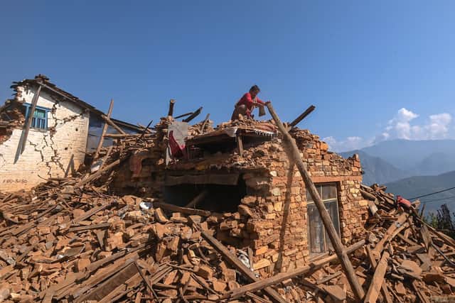 TOPSHOT - A survivor searches for belongings through the ruins of her damaged house following an earthquake in Khalanga of Jajarkot district.
