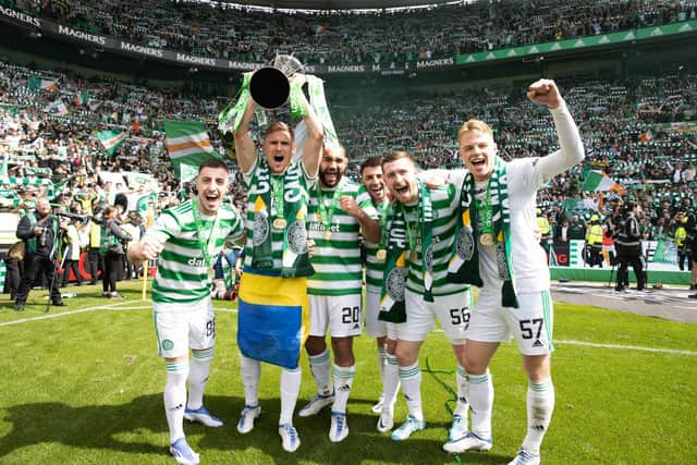 Carl Starfelt holds the Premiership trophy aloft alongside some of his Celtic team-mates. (Photo by Craig Williamson / SNS Group)