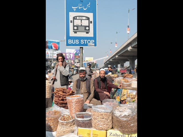 Pashtun men run an open-air dried fruit market