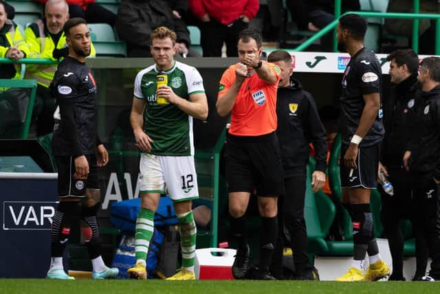 Referee Don Robertson checks the VAR monitor before awarding Hibs a penalty.