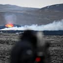A man with camera films an area with glowing lava near the southwestern Icelandic town of Grindavik after a volcanic eruption on Sunday.