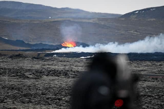 A man with camera films an area with glowing lava near the southwestern Icelandic town of Grindavik after a volcanic eruption on Sunday.