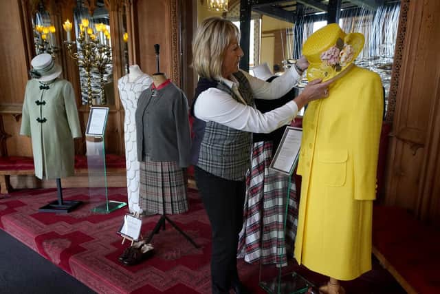 Assistant curator Sarah Hoare adjusts outfits worn by Queen Elizabeth II whilst at Balmoral. Pic: Andrew Milligan