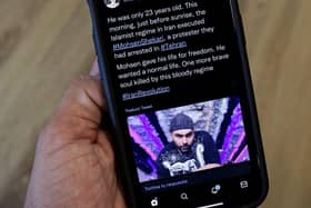 A phone displays a Tweet about the hanging by Iranian authorities of Mohsen Shekari. Picture: AFP via Getty Images