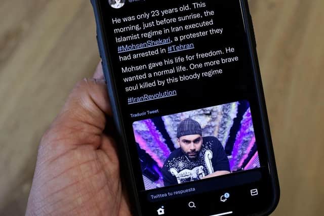 A phone displays a Tweet about the hanging by Iranian authorities of Mohsen Shekari. Picture: AFP via Getty Images