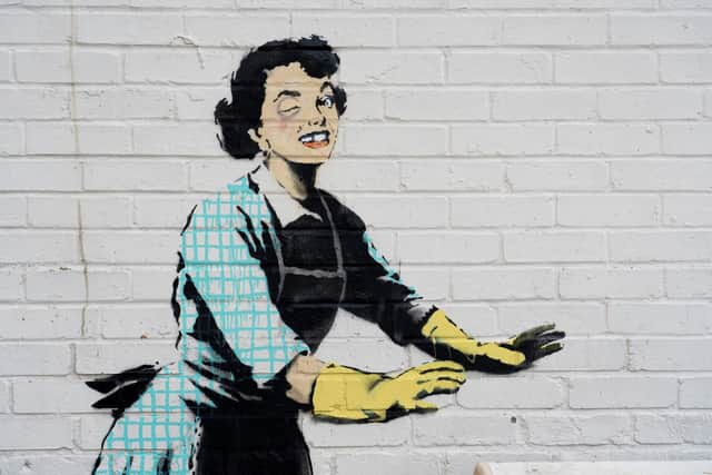 Undated handout file photo of one of the new works by Banksy, appears to show a 1950's housewife, wearing a classic blue pinny and yellow washing up gloves, with a swollen eye and a missing tooth seemingly shoving her male partner into a chest freezer, the piece is set on a white wall backdrop in Kent. Issue date: Tuesday February 14, 2023.