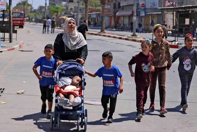Members of a Palestinian family in Beit Hanun in the northern Gaza Strip, flee to a safer location, on May 14, 2021. - Israel pounded Gaza and deployed extra troops to the border as Palestinians fired barrages of rockets back, with the death toll in the enclave on the fourth day of conflict climbing to over 100. (Photo by MAHMUD HAMS / AFP) (Photo by MAHMUD HAMS/AFP via Getty Images)