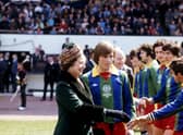 Kenny Dalglish introduces Queen Elizabeth II to members of the Glasgow Select XI before the match against a Football League XI at Hampden Park. The match was in aid of the Silver Jubilee Appeal.