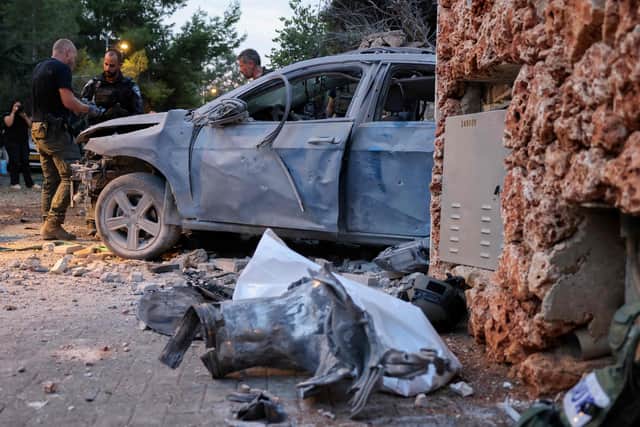 Israeli security forces inspect a car, damaged in a rocket attack from Gaza in Har Adar, a settlement northwest of Jerusalem, high in the hills close to the Green Line that separates the occupied West Bank from Israel. Photo: AHMAD GHARABLI/AFP via Getty Images