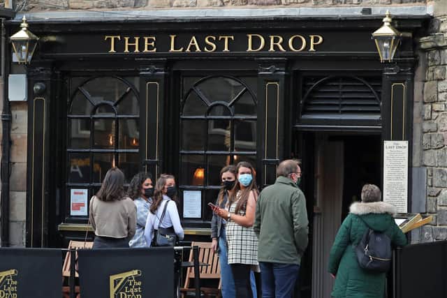 People waiting outside the Last Drop pub in The Grassmarket, Edinburgh, in October.
