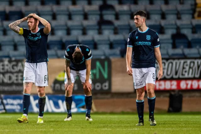 Dundee players are left dejected at full-time after conceding an injury-time goal in the 1-0 defeat to St Mirren.