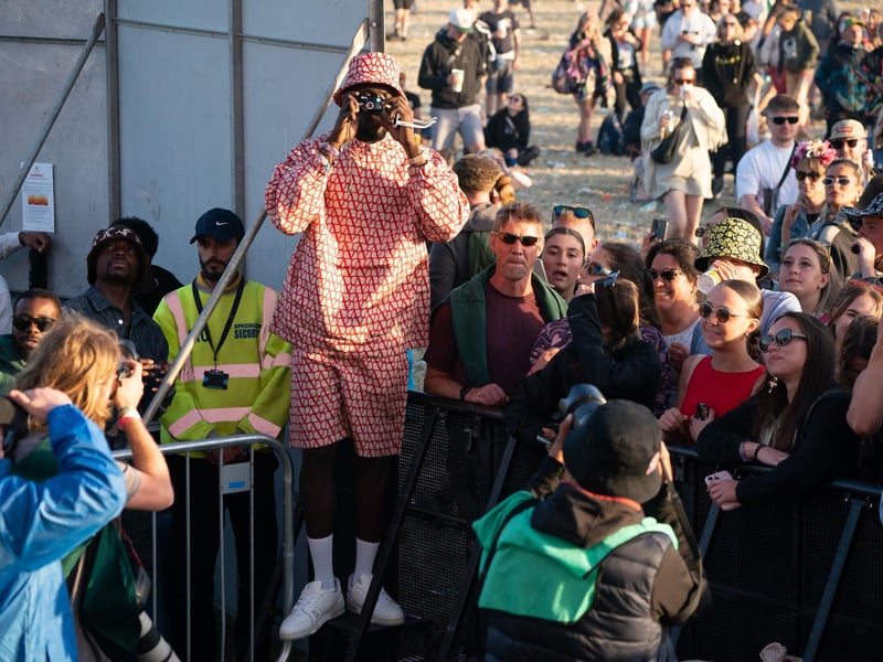 Stormzy takes pictures of the crowd as he watches D-Block Europe from the side of the other stage at Glastonbury