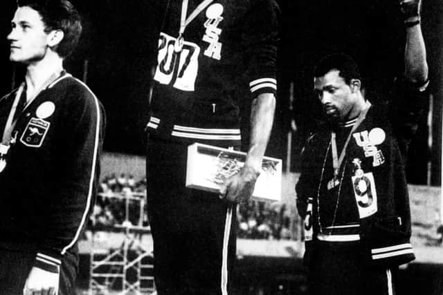 Tommie Smith (C) and John Carlos (R) raise their gloved fists to express their opposition to racism in the USA after receiving their 200m medals at the Mexico Olympic Games in 1968.