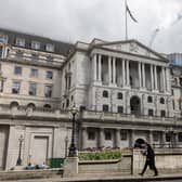 Members of the public walk past the Bank of England in a window as a 0.25 per cent hike in interest rates was announced. Picture: Dan Kitwood/Getty Images