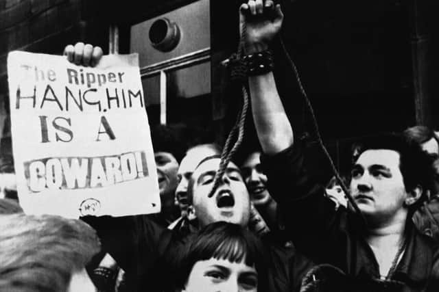 Rwo youths, one holding a noose, right, stand outside Dewsbury Magistrates Court, where Peter William Sutcliffe, was remanded in custody for eight days, charged with the murder on Nov. 17, 1980 of 20-year-old student Jacqueline Hill, who has been described as the 13th victim of the Yorkshire Ripper.