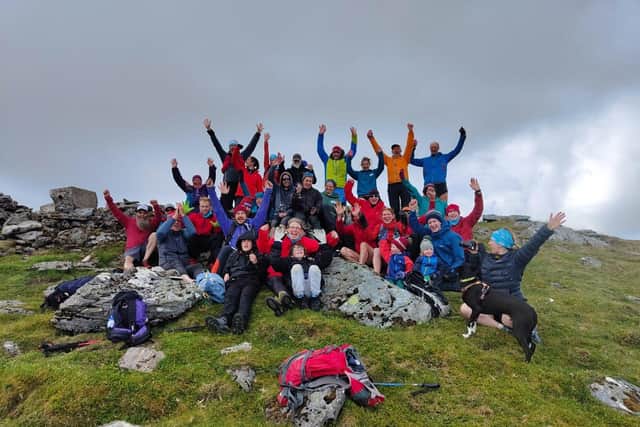 Ultra-runner Jamie Aarons, 43, (centre holding glass) celebrating with supporters at the end of the trek - known as Jamie's Munro Challenge. Picture: Andy Stark/Stark Images/PA Wire