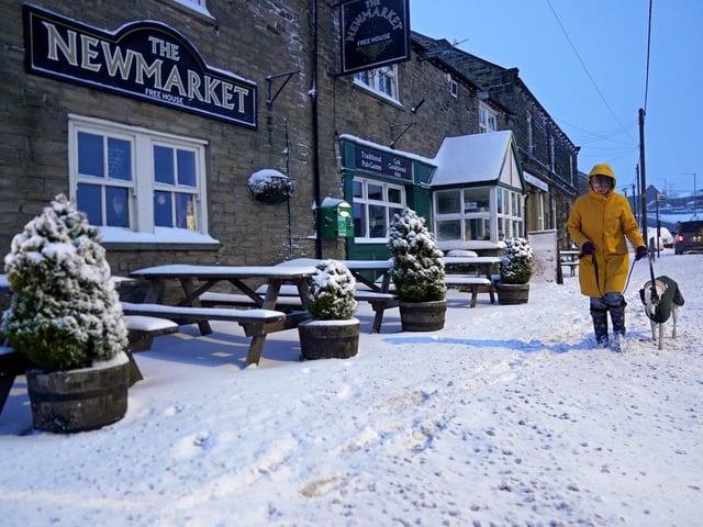 A woman walks her dog in Tow Law, Co Durham, after heavy overnight snow