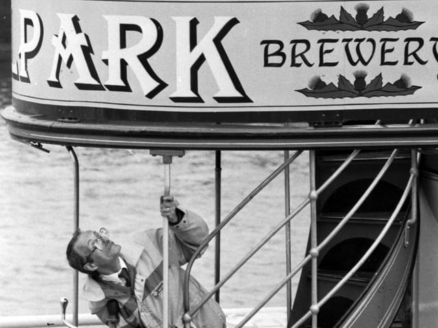 Glasgow Garden Festival tram driver Stanley Kerr strains for a glimpse of the new Tennent's lager models on the top deck, May 1988