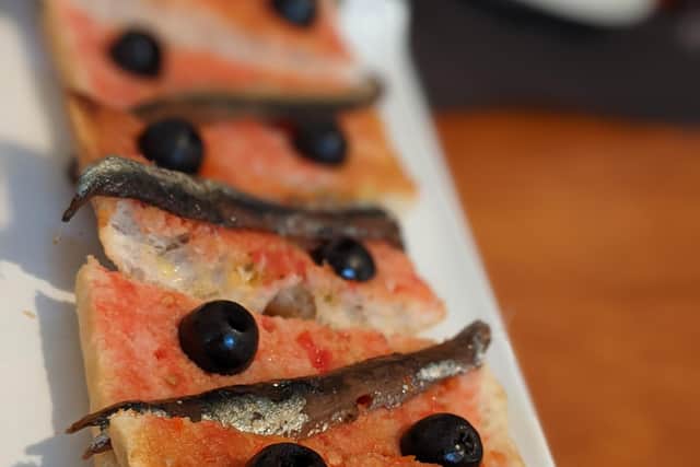 A slice of Spanish toast, painted with tomato instead of butter and topped with local anchovies, at Bau Bar, Girona.