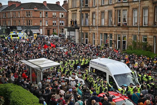 The crowd waits for police to escort two men detained by the Home Office after protestors blocked the immigration van from leaving Kenmure Street on May 13, 2021. Picture: Jeff J Mitchell/Getty Images
