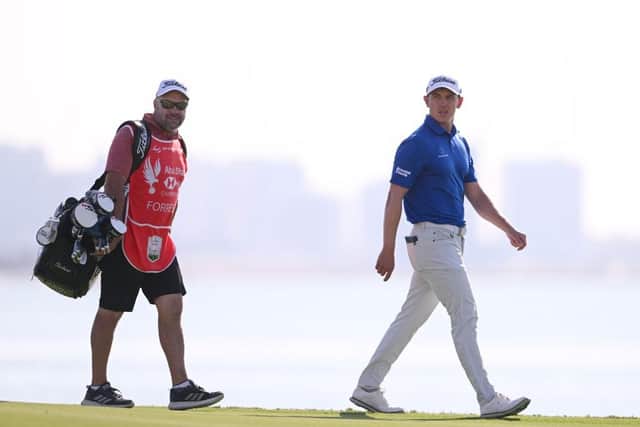 Grant Forrest and his caddie Davy Kenny walk on the 18th green during day three of the Abu Dhabi HSBC Championship at Yas Links. Picture: Ross Kinnaird/Getty Images.