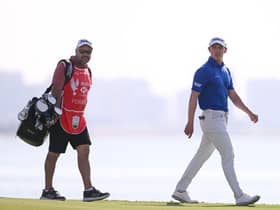 Grant Forrest and his caddie Davy Kenny walk on the 18th green during day three of the Abu Dhabi HSBC Championship at Yas Links. Picture: Ross Kinnaird/Getty Images.