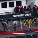 Migrants are escorted ashore from the UK Border Force vessel 'BF Ranger' in Dover earlier this year after having been picked up at sea while attempting to cross the English Channel.