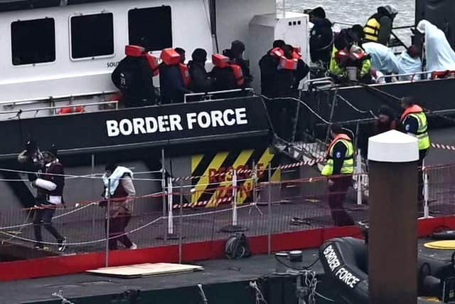 Migrants are escorted ashore from the UK Border Force vessel 'BF Ranger' in Dover earlier this year after having been picked up at sea while attempting to cross the English Channel.