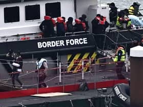 Migrants are escorted ashore from the UK Border Force vessel 'BF Ranger' in Dover earlier this year after having been picked up at sea while attempting to cross the English Channel.