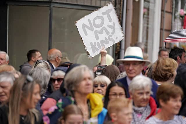 A protester holds up a "Not My King" placard in the crowd as people wait to greet Britain's King Charles III and Britain's Queen Camilla. Picture: Andrew Milligan/AFP via Getty Images