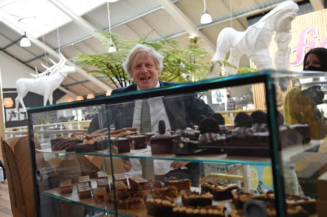 Boris Johnson eyes up a display of cakes and desserts on a trip to Truro (Picture: Justin Tallis/WPA pool/Getty Images)