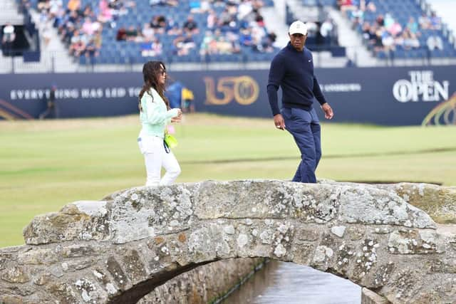 Tiger Woods walks over the Swilcan Bridge with partner Erica Herman during a practice round prior to The 150th Open at St Andrews. Picture: Warren Little/Getty Images.