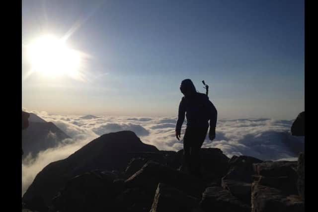 A silhouette photo of Mike on the summit of Liathach in Torridon.