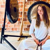 Jo McCoy sitting in front of her gongs