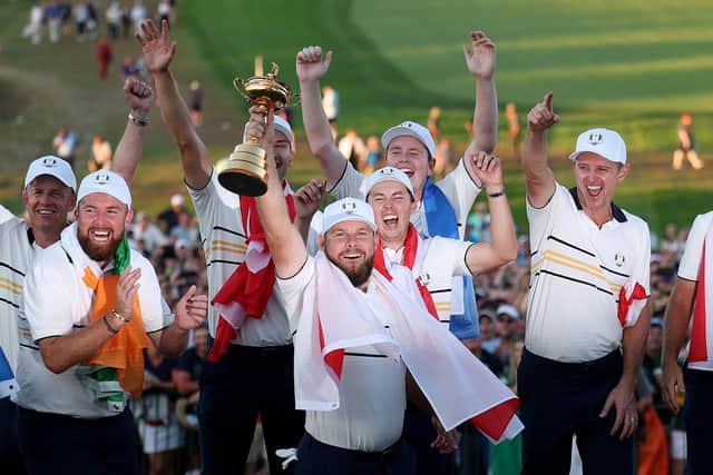 Tyrrell Hatton of Team Europe lifts the Ryder Cup trophy as teammates celebrate their 15-13 win over Team United States (Picture: Andrew Redington/Getty Images)