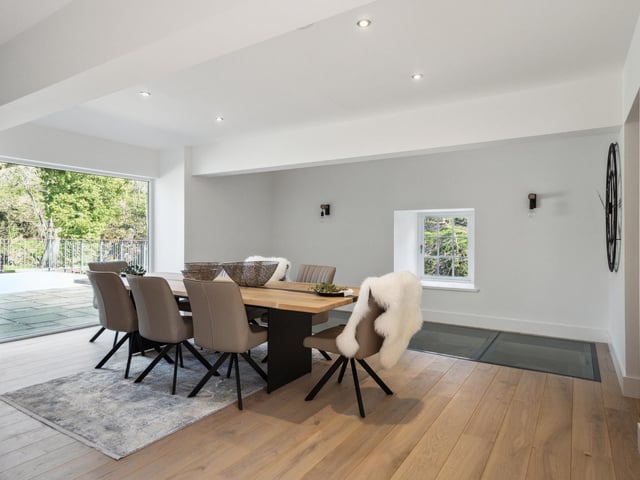 Interior: A contemporary open-plan kitchen-dining space leads to a formal lounge and whisky snug/fifth bedroom. Bedrooms two, three and a principal bedroom suite are upstairs, while a fourth ensuite bedroom is accessed separately.