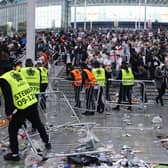 Stewards replace barricades after they were knocked over by supporters outside Wembley on July 11.