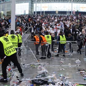 Stewards replace barricades after they were knocked over by supporters outside Wembley on July 11.