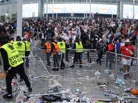Stewards replace barricades after they were knocked over by supporters outside Wembley on July 11.