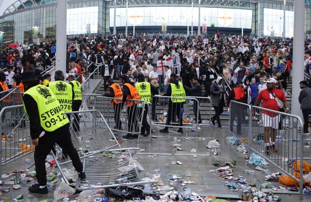 Stewards replace barricades after they were knocked over by supporters outside Wembley on July 11.