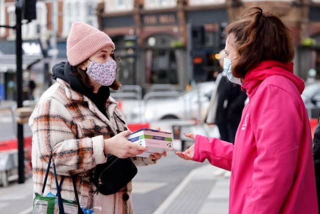 Volunteers hand out boxes of Covid-19 rapid antigen Lateral Flow Tests (LFT), in north east London on January 3, 2022. Photo by TOLGA AKMEN/AFP via Getty Images
